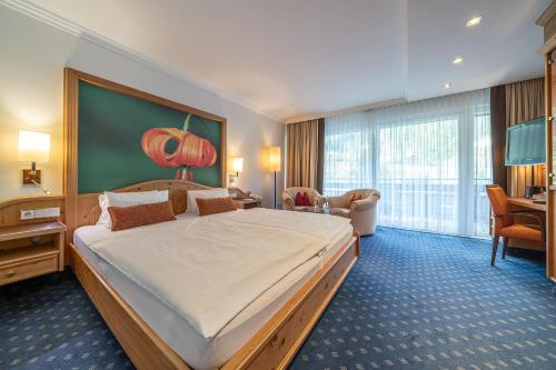 a hotel room with a large bed and a desk at EUROPÄISCHER HOF Bad Gastein in Bad Gastein