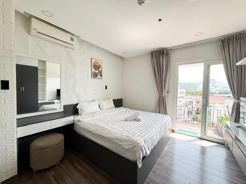 a bedroom with a bed and a large window at Modern Garden Apt by Dragon bridge in Da Nang