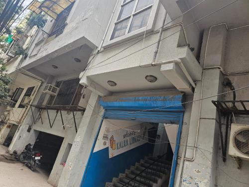 a building with a blue awning on the side of it at GAUTAM NAGAR HOMESTAY NEAR AIIMS Hospital in New Delhi