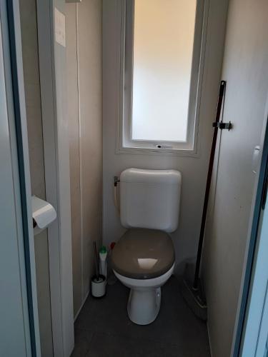 Elle comprend une petite salle de bains pourvue de toilettes et d'une fenêtre. dans l'établissement MOBILE HOME 3 CHAMBRES, à Hyères