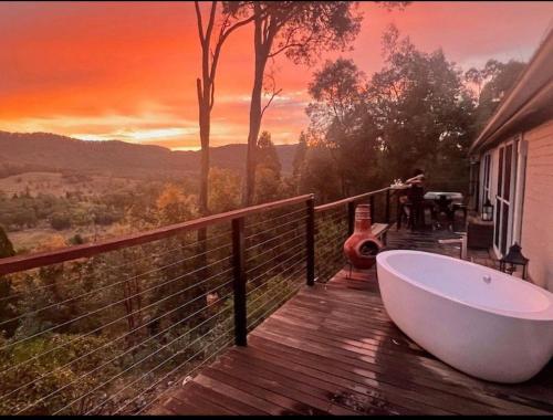 a bath tub sitting on a wooden deck with a view at RIVERLEA RETREAT MUDGEE - Private, Outdoor Bath, Pool, Tranquility in Apple Tree Flat