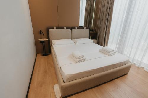 a bedroom with a bed with white sheets and pillows at MIKU Green Coast in Palasë