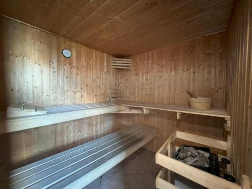 a wooden sauna with a clock on the wall at Chalets am Feuerkogel - LANDLUFT in Ebensee