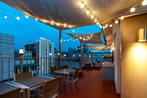 a rooftop deck with tables and chairs and lights at Hotel Ippda Wonju in Wonju