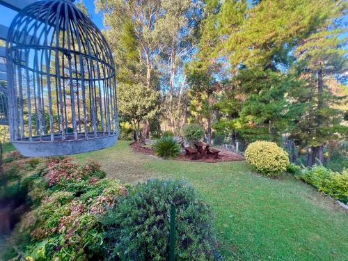 a bird cage is hanging over a garden at RIVERLEA RETREAT MUDGEE - Private, Outdoor Bath, Pool, Tranquility in Apple Tree Flat