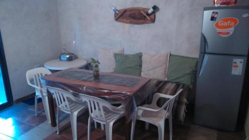 cocina con mesa, sillas y nevera en CABAÑAS LDM en San Isidro
