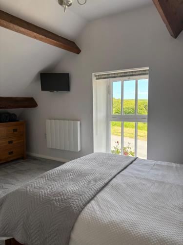 een slaapkamer met een groot bed en een raam bij The Hayloft Cottage in Whitby