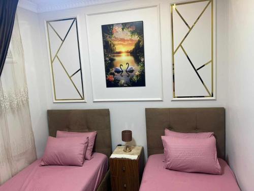 two beds with pink sheets in a room with windows at بورتو مطروح - Porto Matrouh in Marsa Matruh