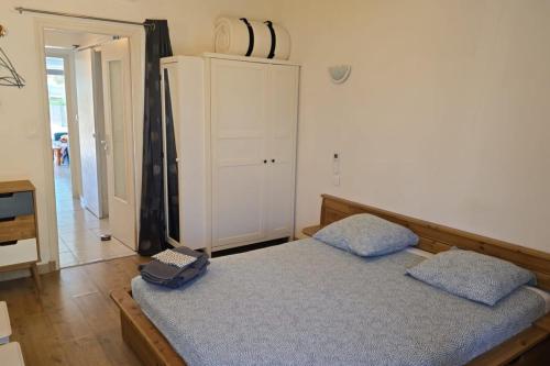 une chambre avec un lit avec deux oreillers bleus dans l'établissement Naturiste Cap d'Agde Villa Héliovillage 33, au Cap d'Agde