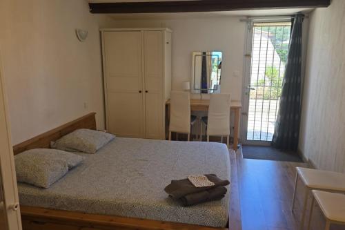une chambre avec un lit, une table et une fenêtre dans l'établissement Naturiste Cap d'Agde Villa Héliovillage 33, au Cap d'Agde