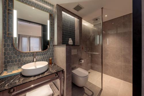 a bathroom with a sink and a toilet and a shower at La Siesta Premium Lakeside in Hanoi
