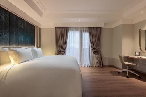 a hotel room with a bed and a desk at La Siesta Premium Lakeside in Hanoi