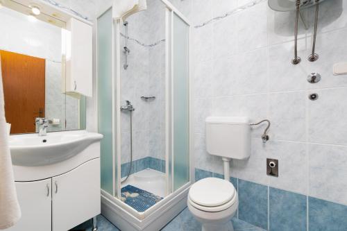 a bathroom with a toilet and a sink and a shower at Apartments Bogović in Malinska