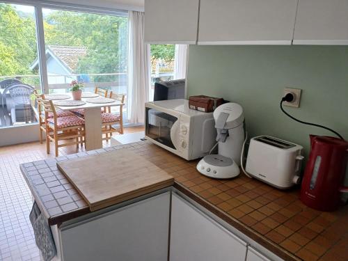 a kitchen with a microwave on a counter with a table at Coquelicot in Waulsort
