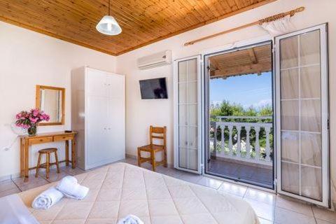 a bedroom with a large glass door to a balcony at Villa Georgia in Argassi