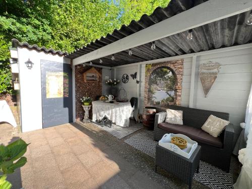 a patio with a couch and a table at Chalet Royal romantisch, uniek en volledig privé in Putten