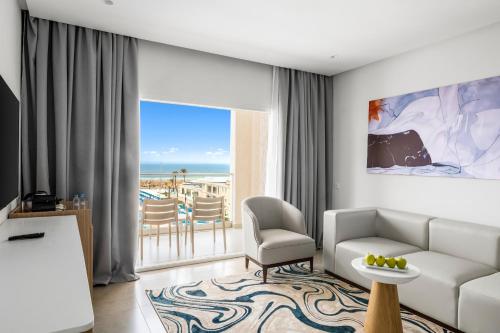 a living room with a couch and a room with a view at Pickalbatros Palais Des Roses - Agadir - All Inclusive in Agadir