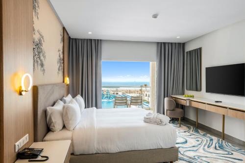 a hotel room with a bed and a television at Pickalbatros Palais Des Roses - Agadir - All Inclusive in Agadir