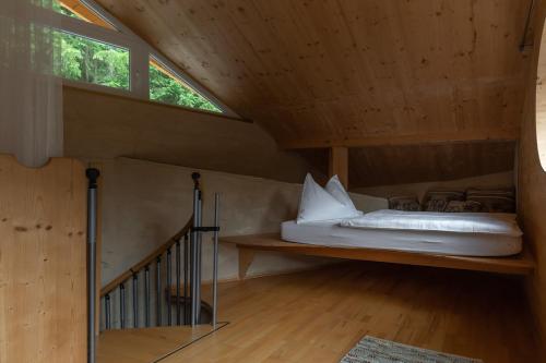 a bed in the attic of a wooden house at Aurora - Faszination Natur in Kraig