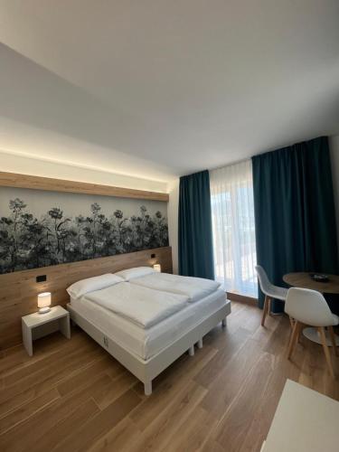 a bedroom with a bed and a desk and a table at Agritur Gasadòr in Trento