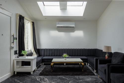 a living room with a black couch and a table at Sitara Palace and Resort in Bhopal