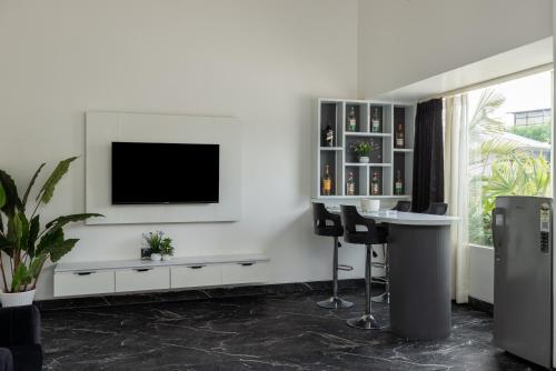 a living room with a tv on a white wall at Sitara Palace and Resort in Bhopal