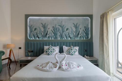 a bedroom with a bed with two swans on it at Sitara Palace and Resort in Bhopal