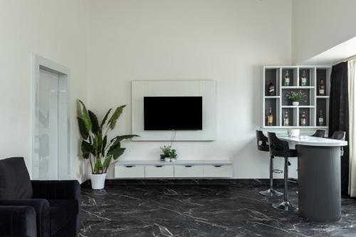 a living room with a tv on a white wall at Sitara Palace and Resort in Bhopal