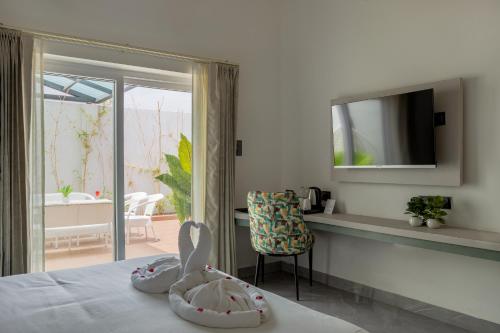 a bedroom with a bed with a television and a chair at Sitara Palace and Resort in Bhopal