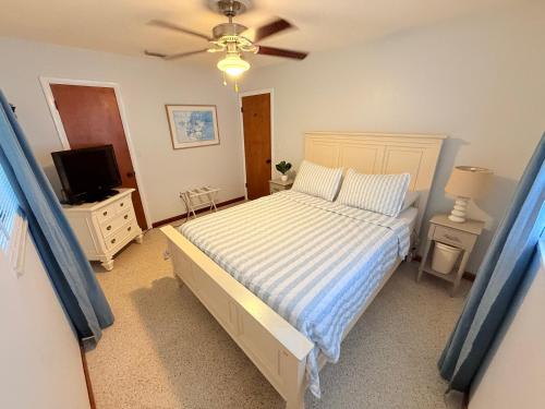 a bedroom with a bed and a flat screen tv at The Wavestay I 4 min walk to Beach in Satellite Beach