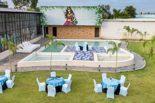 a group of tables and chairs in front of a pool at Sitara Palace and Resort in Bhopal