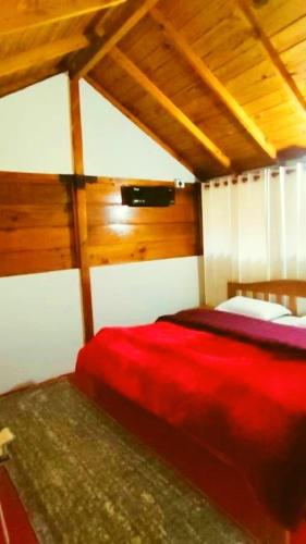 a bedroom with a red bed in a room at Harsil Retreat in Harsil