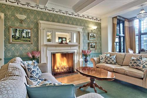 a living room with couches and a fireplace at Caer Beris Hotel in Builth Wells