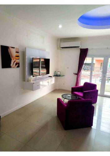 a living room with two purple chairs and a blue frisbee at Titanic Residence-7 minute walk to the Beach in Pattaya Central