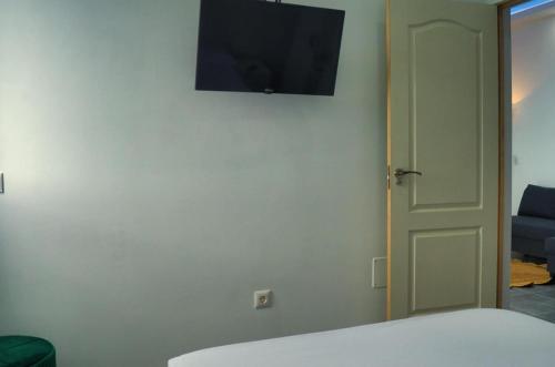 a room with a tv on the wall and a door at La Ladera in Frontera