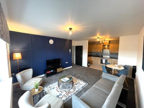 a living room with a couch and a table at Parkside Mayfair Apartment in Wakefield