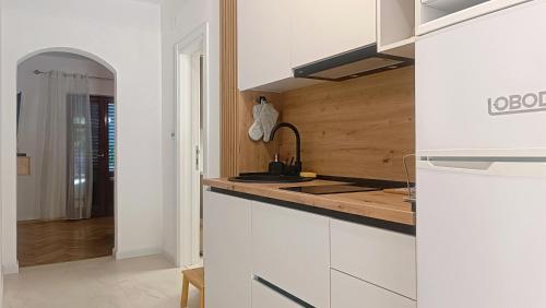 a white kitchen with a sink and a counter at Apartments Nada in Budva