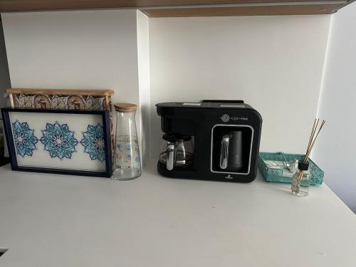 a black coffee maker and a picture on a counter at Luxury Seafront Duplex Villa With Pool9 in Cesme