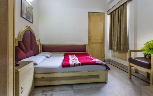 a bedroom with a bed with a red blanket on it at Hotel Sun Shine in New Delhi