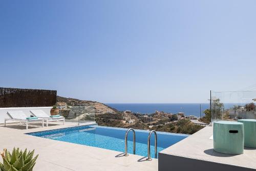 a swimming pool with a view of the ocean at Royal Garden Villas in Balíon