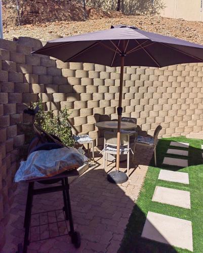 an umbrella on a patio with a table and chairs at Windhoek self accommodation in Windhoek