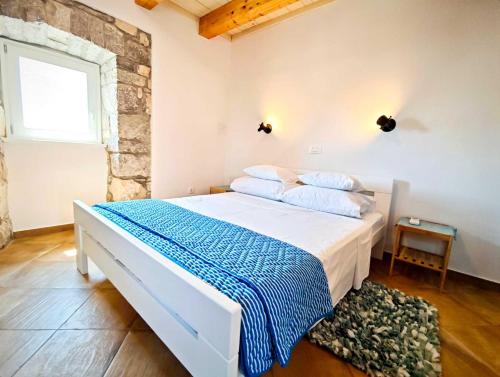SkrbčićiにあるHoliday house Mayaのベッドルーム(白いベッド、青い毛布付)