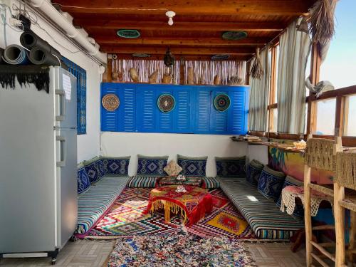 a room with a table and a couch in a room at Hostel blue house Taghazout in Taghazout