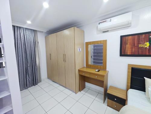 a room with a bedroom with a desk and a bed at AB Luxury 2 bedroom Apartment with 24hr Electricity, Wifi, Fully Equipped Kitchen in Lagos