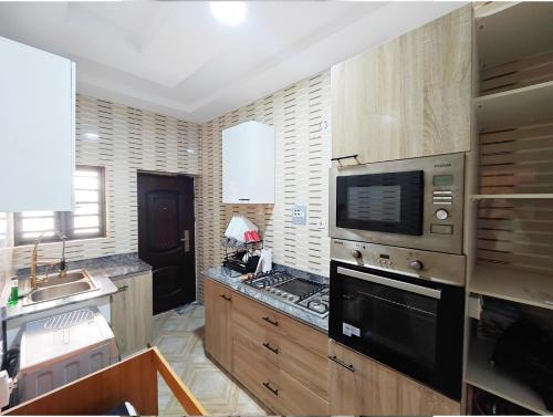 a kitchen with a stove and a microwave at AB Luxury 2 bedroom Apartment with 24hr Electricity, Wifi, Fully Equipped Kitchen in Lagos