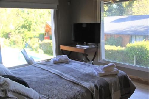 a bedroom with a bed and a large window at Casa Don Alfredo in San Carlos de Bariloche