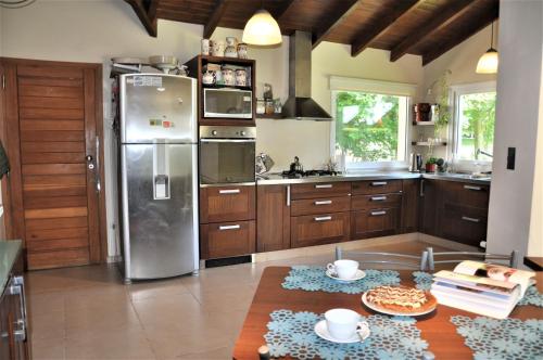 a kitchen with a stainless steel refrigerator and wooden cabinets at Casa Don Alfredo in San Carlos de Bariloche