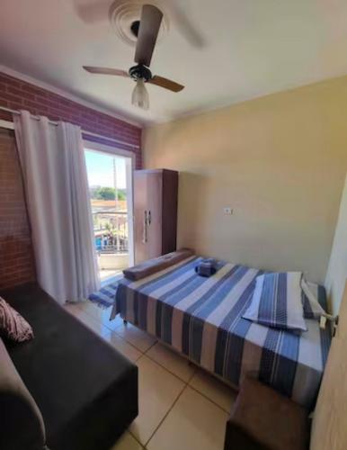 a bedroom with a bed and a ceiling fan at Cantinho da Canastra in Água Boa