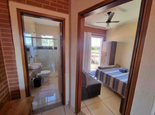 a room with a bedroom with a bed and a bathroom at Cantinho da Canastra in Água Boa