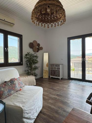 a living room with a couch and a chandelier at Welcoming 3 Bedroom Home in Perdika, Thesprotias in Perdika